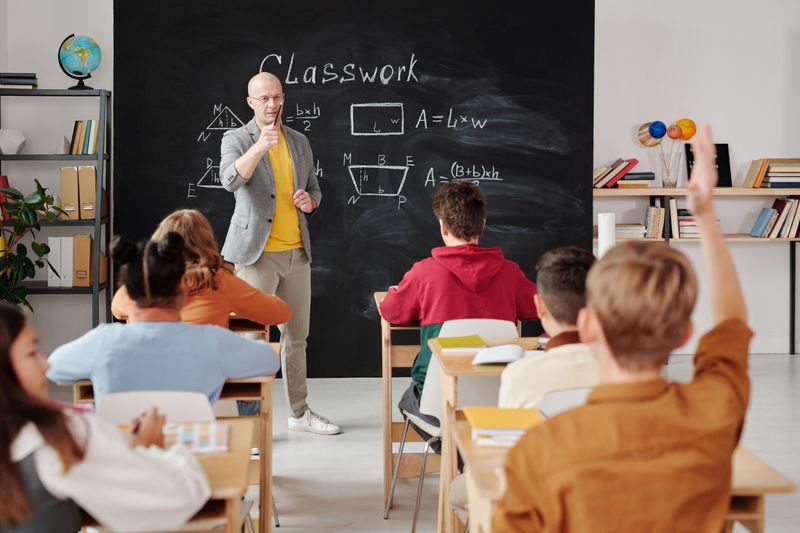Students in bright classroom viewing presentation on large screen
